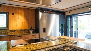 Una cocina moderna con encimera de granito, electrodomésticos de acero inoxidable y un amplio ventanal que proporciona luz natural.