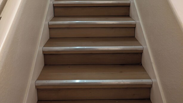 A staircase with beige steps and white walls.