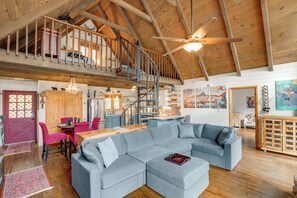 A spacious living area with a large gray sectional sofa, a wooden dining table with chairs, a staircase to an upper level, and a ceiling fan. - Walk to Slopes: Mars Hill Resort-Style Mtn Chalet (Mars Hill)