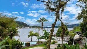 Ein tropisches Resort mit Schwimmbad, Palmen und Meerblick.