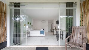Una habitación moderna con una cama, una mesita pequeña y un banco.