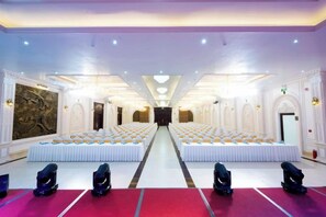 A large hall with rows of white tables and chairs, a central aisle, and a red carpet. - Cantho Eco Resort (Can Tho)