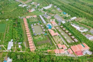 An aerial view of a resort with multiple buildings, a swimming pool, and surrounding greenery. - Cantho Eco Resort (Can Tho)