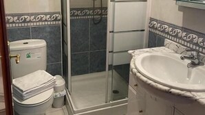A bathroom with a glass-enclosed shower, a white sink, and a toilet. - Pension San Vicente (San Vicente de la Sonsierra)