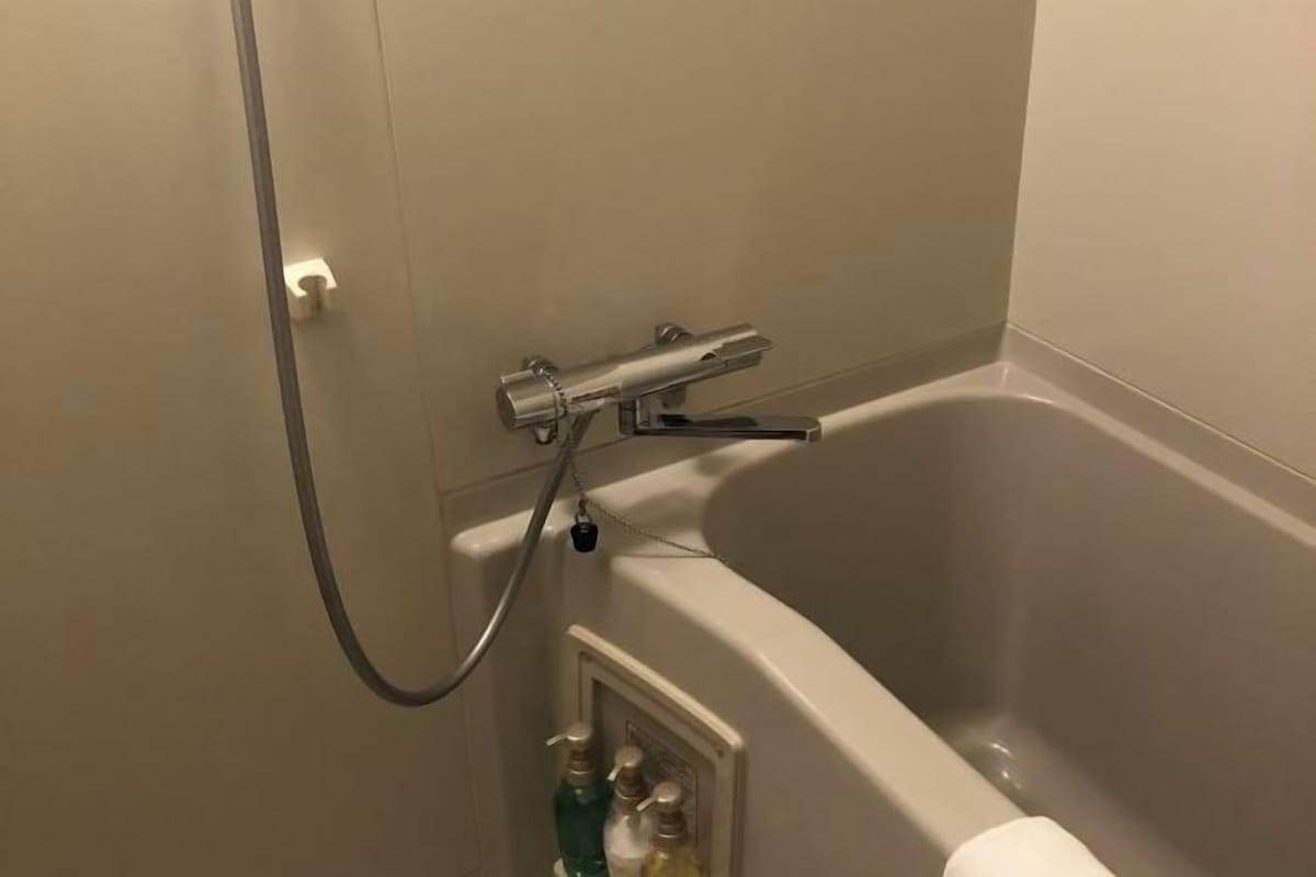 Un baño con bañera, ducha y perchero.