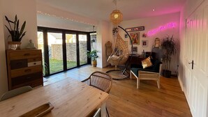 Un soggiorno moderno con un tavolo da pranzo in legno, una poltrona a dondolo e un neon.
