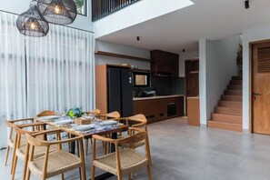 Een moderne keuken met donkere kastjes, een zwarte koelkast en een houten aanrecht.