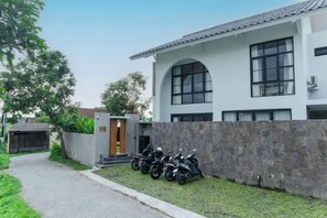 Ein modernes, zweistöckiges Haus mit gepflasterter Auffahrt und einer Steinmauer.