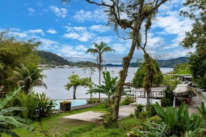 Ein tropisches Resort mit Schwimmbad, Palmen und Meerblick.