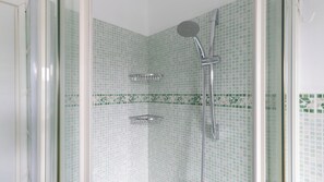 A shower with a handheld showerhead and a wall-mounted faucet, tiled with a green and white pattern. - Italianway Easy - Scarampo 41 (Milano)