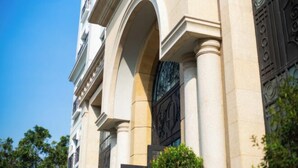 A building with classical architecture, featuring columns and an arched entrance. - CityHouse - Atelier Thao Dien (Ho Chi Minh City)