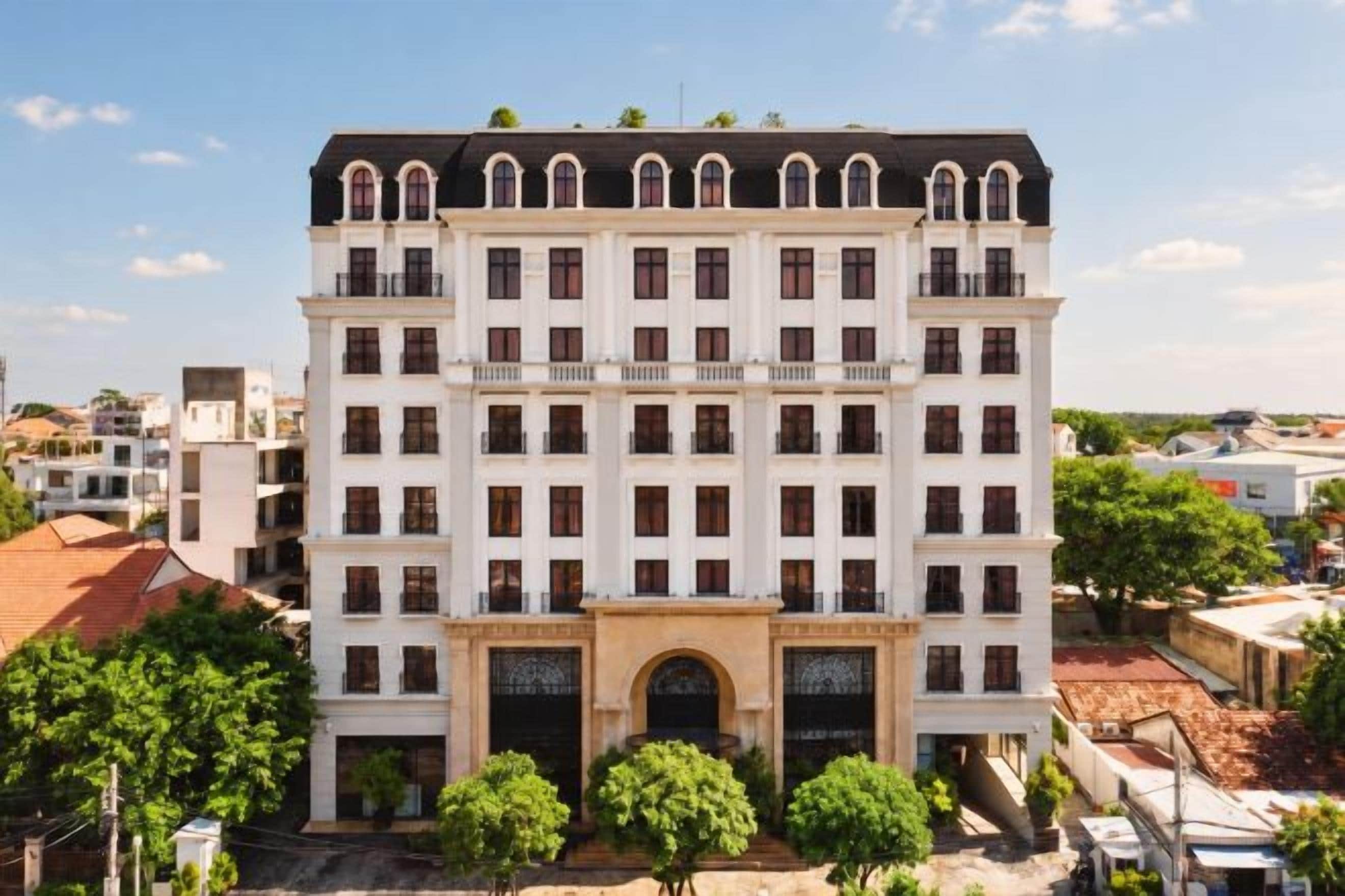 A multi-story building with a symmetrical facade, large windows, and a central entrance with a decorative arch.