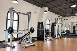 A gym with weightlifting equipment, large windows, and a wooden floor. - CityHouse - Atelier Thao Dien (Ho Chi Minh City)