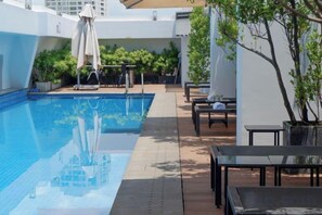 A swimming pool with a tiled deck, surrounded by outdoor furniture and potted plants. - CityHouse - Atelier Thao Dien (Ho Chi Minh City)