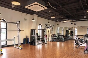 A gym with exercise equipment, large windows, and a high ceiling. - CityHouse - Atelier Thao Dien (Ho Chi Minh City)