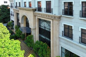 A multi-story building with a central courtyard, featuring a large arched entrance and a decorative iron gate. - CityHouse - Atelier Thao Dien (Ho Chi Minh City)