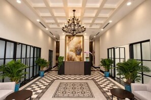 A hotel lobby with a checkered floor, a reception desk, and potted plants. - CityHouse - Atelier Thao Dien (Ho Chi Minh City)