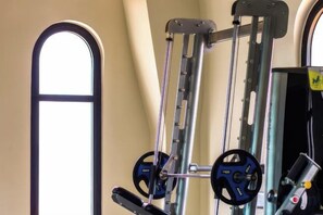 A gym with exercise equipment, including a pull-up bar and weight plates. - CityHouse - Atelier Thao Dien (Ho Chi Minh City)