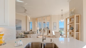 A spacious kitchen with a large island, double sinks, and a view to the living area. - Palm Harbor #704 (Fort Myers Beach)
