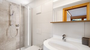 Une salle de bain moderne équipée d’une douche, de toilettes et d’un lavabo.
