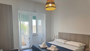 A modern bedroom with a bed, bedside tables, and a hanging light fixture. - Sapore Di Mare Riviera (Gaeta)