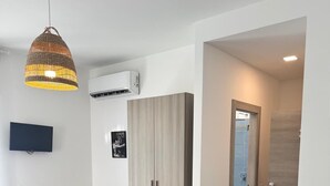 A modern bedroom with a bed, a chair, a wardrobe, and a TV. - Sapore Di Mare Riviera (Gaeta)