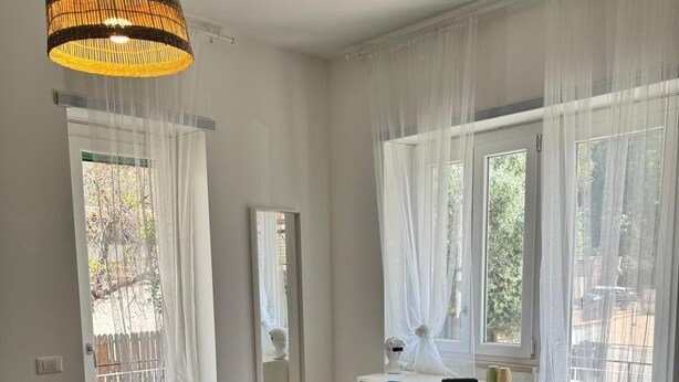 A room with a desk, chair, and a hanging light fixture. - Sapore Di Mare Riviera (Gaeta)