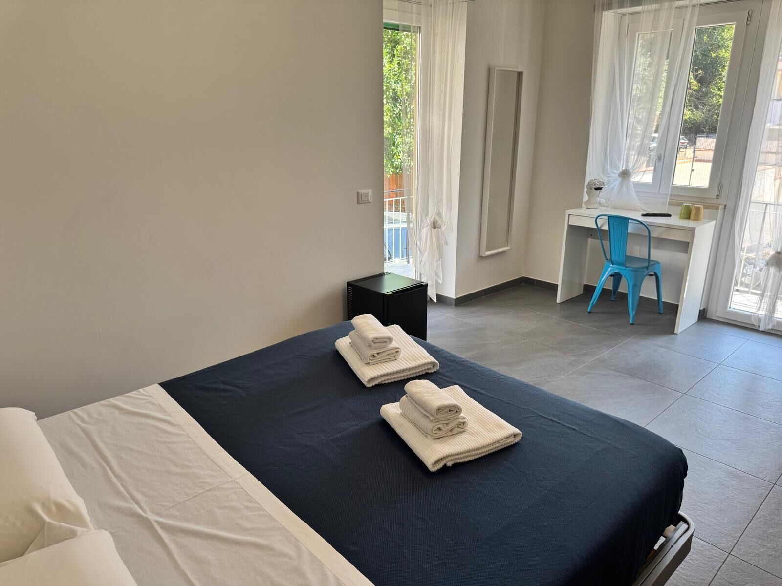 Una habitación de hotel con cama, escritorio y silla.