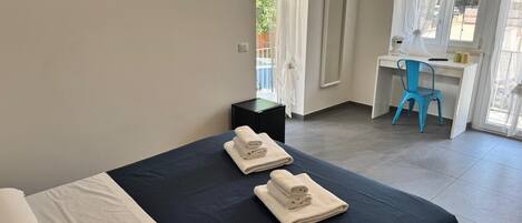 Ein Hotelzimmer mit Bett, Schreibtisch und Stuhl.