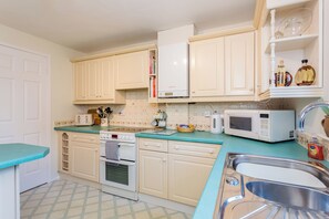 A kitchen with white cabinets, a microwave, a toaster, and a sink. - Toast Stays - Elgin Escape (Darlington)
