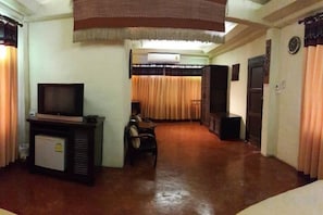 A hotel room with a television, a small refrigerator, a dining table, and a sofa. - Sri Ping Resort (Chiang Mai)