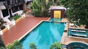A rectangular swimming pool with a hot tub and a wooden deck area. - Sri Ping Resort (Chiang Mai)