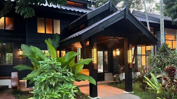 A traditional wooden building with a covered entrance and a well-maintained garden. - Sri Ping Resort (Chiang Mai)