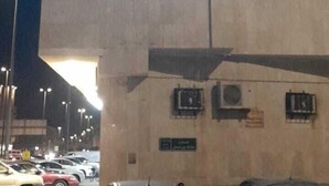 Un bâtiment dont l’enseigne est illuminée et affiche des caractères arabes.