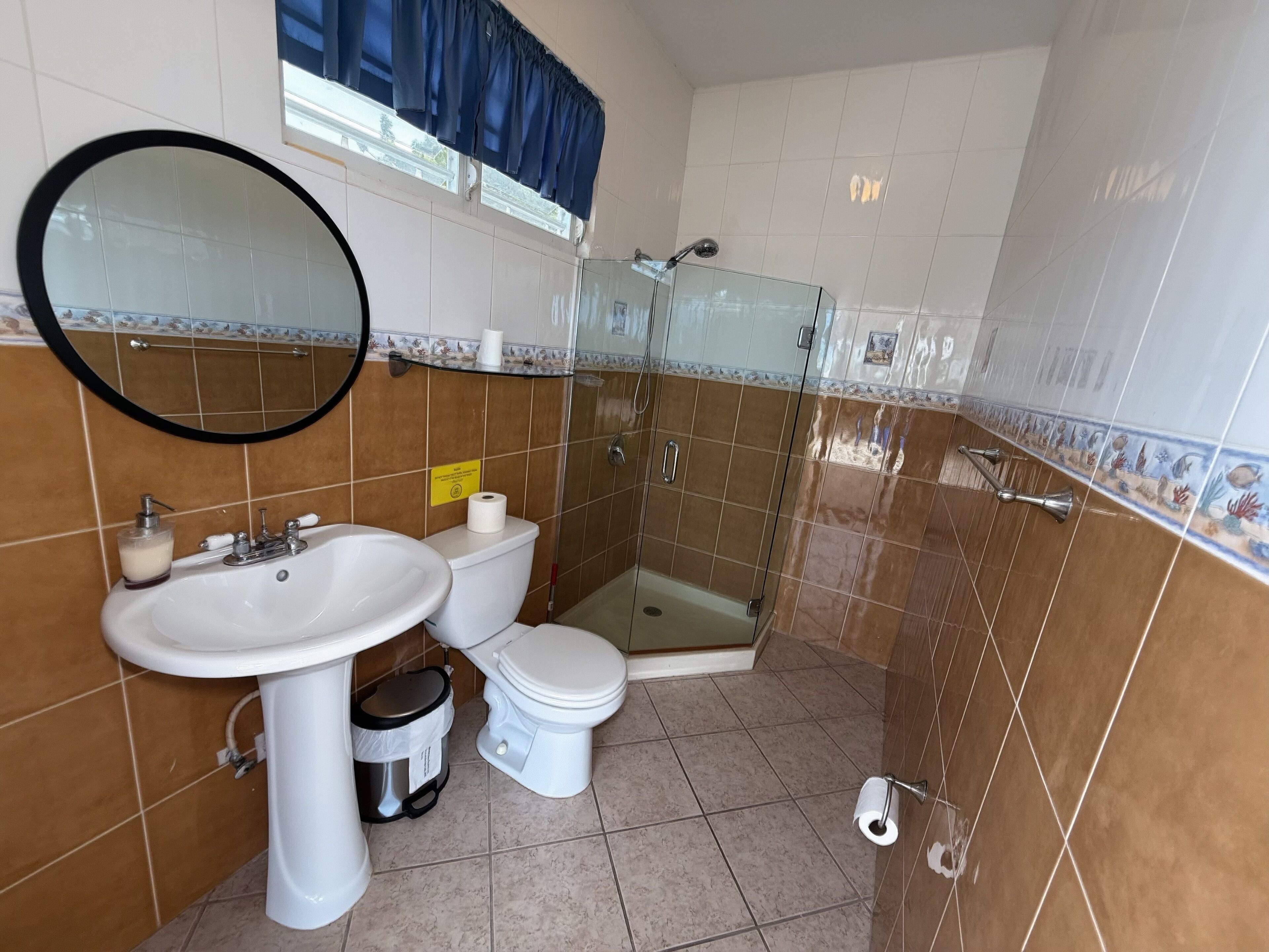 A bathroom with a sink, toilet, and glass shower enclosure.