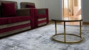 Una habitación con un conjunto de sofás, una mesa redonda y un aplique de pared.