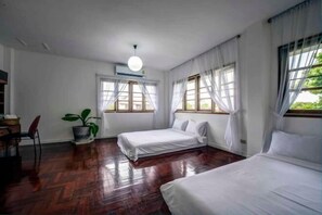 A room with two beds, a desk, a chair, and a potted plant. - DoubleTree House (Chiang Mai)