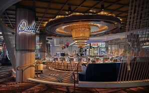 A modern bar area with a circular ceiling design, a bar counter, and patterned seating. - Dogwood Cabin - Cozy Cabin (Sonora)