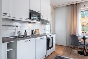 Comfort appartement, balkon | Privékeuken | Een koelkast met diepvriezer, een microgolfoven, een oven, een kookplaat
