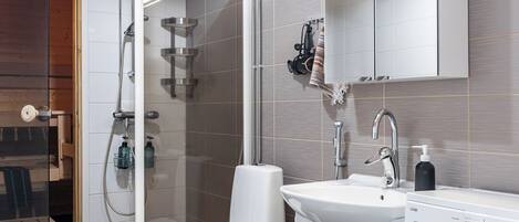 Ein modernes Badezimmer mit Toilette, Waschbecken und Waschmaschine.