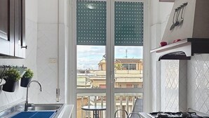 Een moderne keuken met een gasfornuis, een gootsteen en een eethoek met een tafel en stoelen.