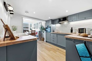 Eine moderne Küche mit grauen Schränken, einer Holz Arbeitsplatte und einem blauen Handtuch.