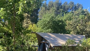A rustic outdoor area with a stone wall, wooden steps, and a tent. - Villa Oriel Naturiste (Figanières)