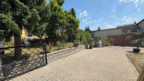 A paved courtyard with a metal gate, potted plants, and a statue. - Vacation apartment (50sqm) with balcony and sun terrace in Frickenhausen (Frickenhausen)