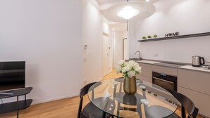 A modern kitchen with a built-in oven, a coffee maker, and a shelf with the word "HOME" above it. - Milan Royal Suites Duomo (Milan)