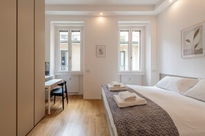 Ein modernes Schlafzimmer mit Bett, Schreibtisch und Stuhl.