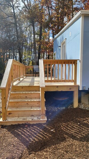 A wooden deck leading to a small building with a window and a door. - Charming tiny house in Rogersville.
Come relax in this quiet country setting (Rogersville)
