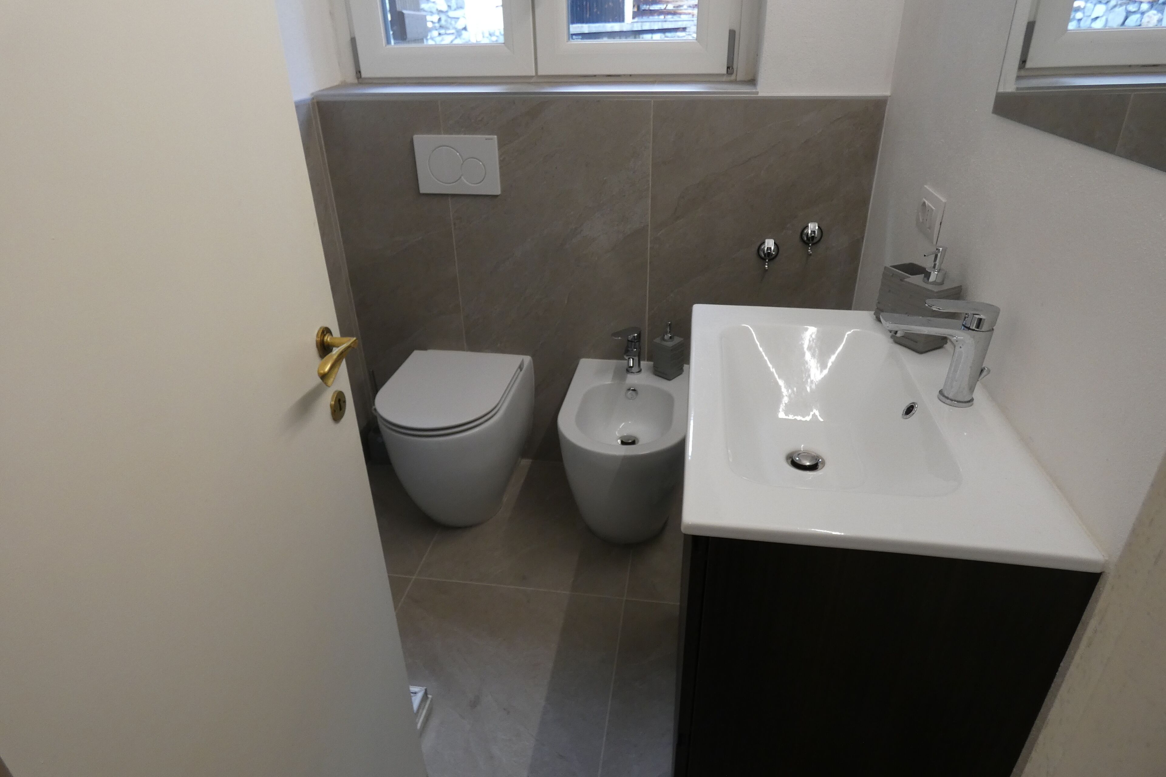 Ein Badezimmer mit Toilette, Bidet und Waschbecken.