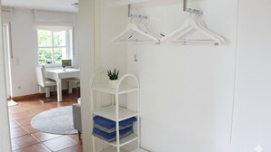 A room with a white wall, a white shelf with towels, and a white hanging rack. - ✨Charming apartment with panoramic views | Eversberg old town in Hochsauerland (Meschede)