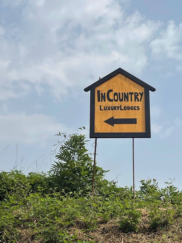 A wooden sign with the text 'InCountry Luxury Lodges' and an arrow pointing left. - In Country Luxury Lodges (Camerino)